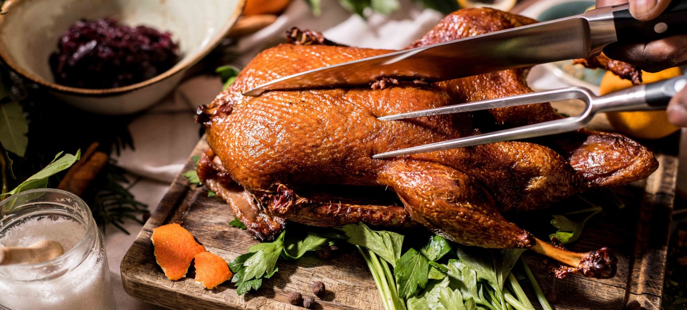 Roast duck is carved on a set table